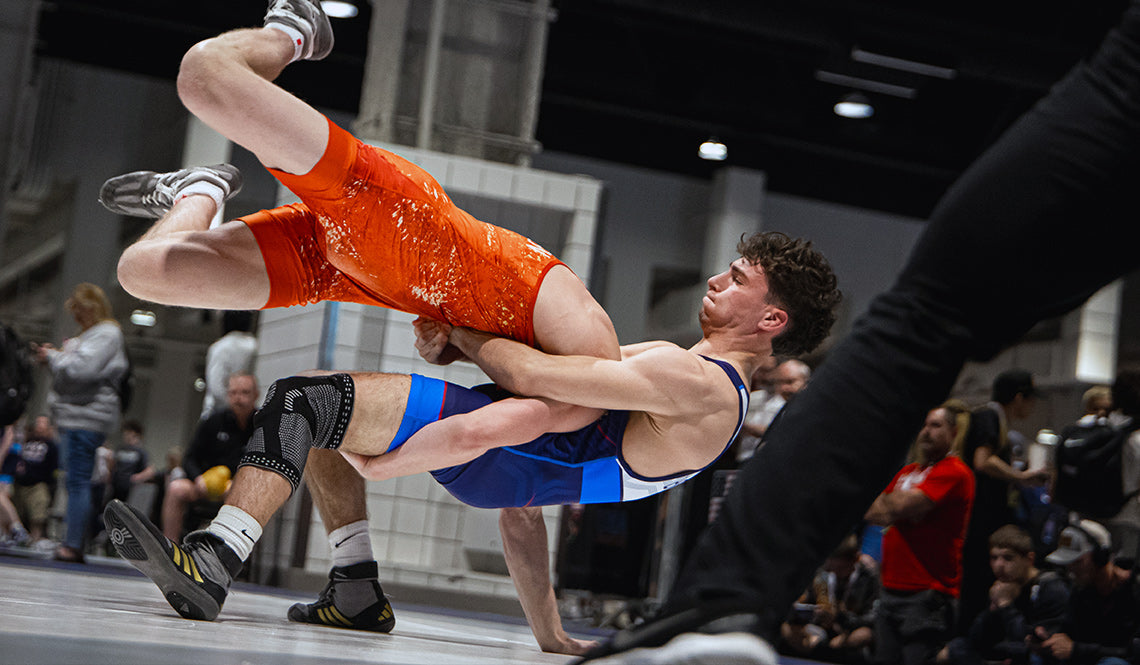 Wrestlers engaged in a heated match on a Dollamur wrestling mat